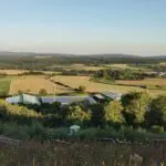 Deponie Brandholz vom Berg runter fotografiert, grüne Landschaft außenrum, inkl. Fotovoltaikanlagen